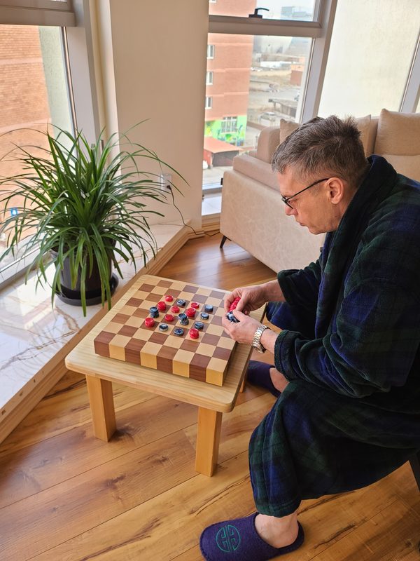 Mark Steere at a checkerboard with red and blue checkers